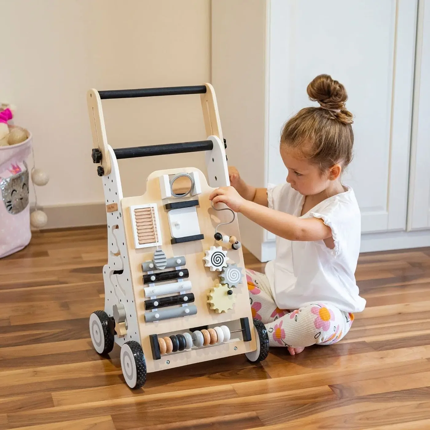 Petite fille joue avec son chariot Montessori
