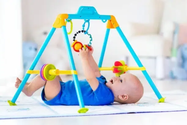 istockphoto-649872012-612x612-1 Un bébé sur un tapis de motricité équipé d'un jouet suspendu
