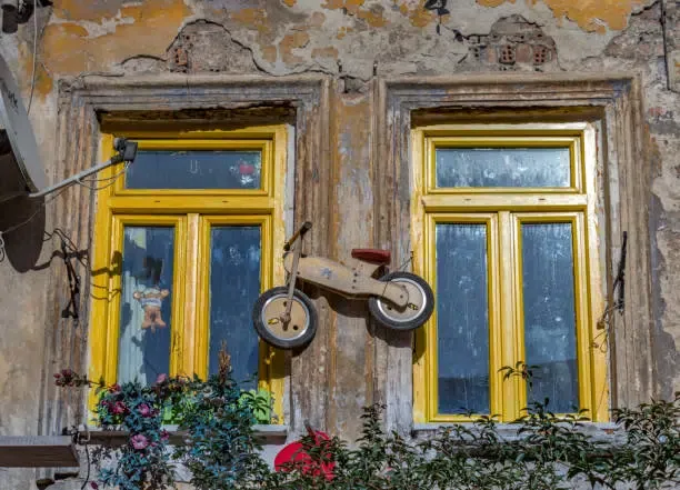Fenêtres à cadre jaune et draisienne en bois.