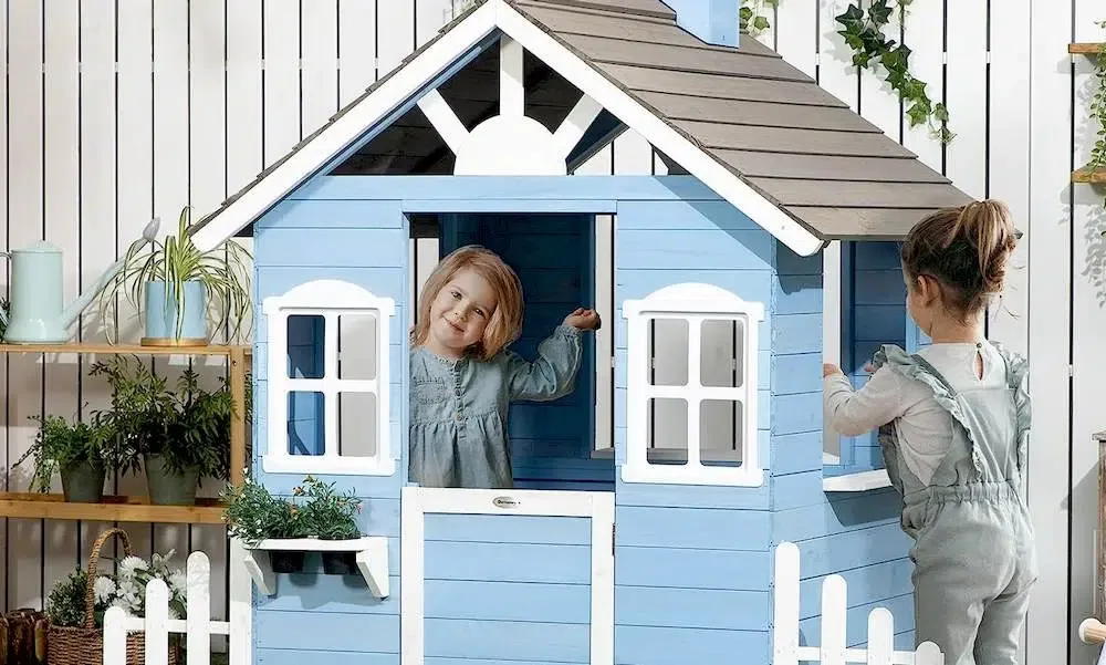 Un enfant à l'intérieur et une autre à l'extérieur d'une maisonnette en bois