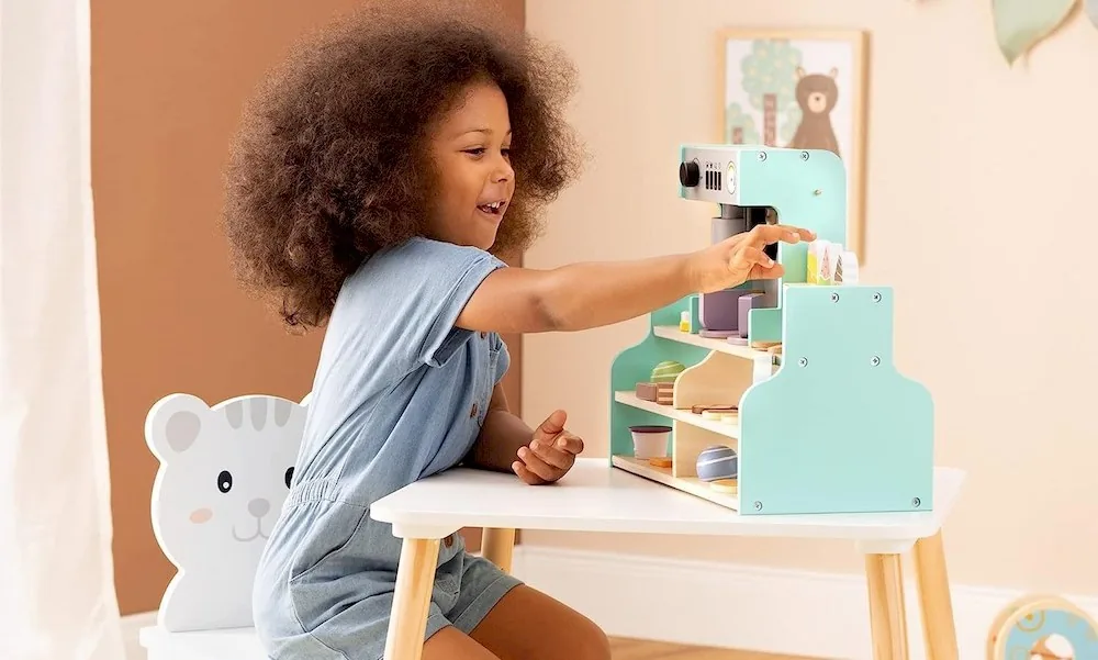 Une petite fille jouant avec une marchande en bois