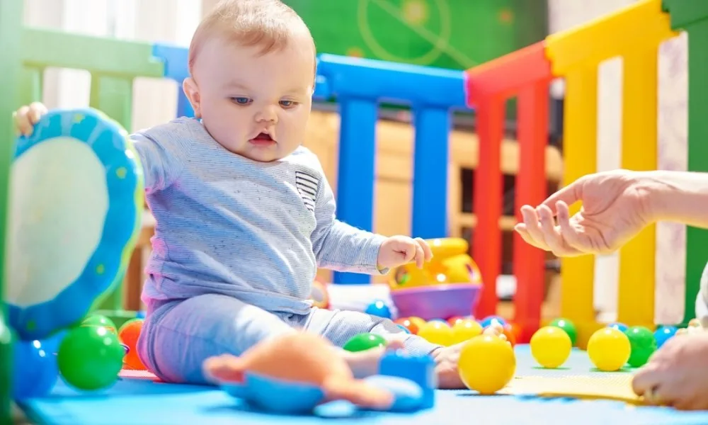 Un bébé dans un parc avec de nombreux jouets