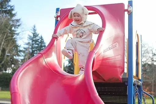 Un enfant qui fait un parcours de motricité en jouant au toboggan