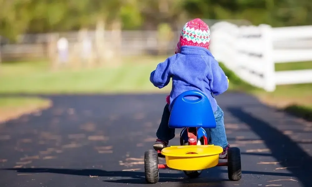 Un enfant jouant avec un tricycle évolutif