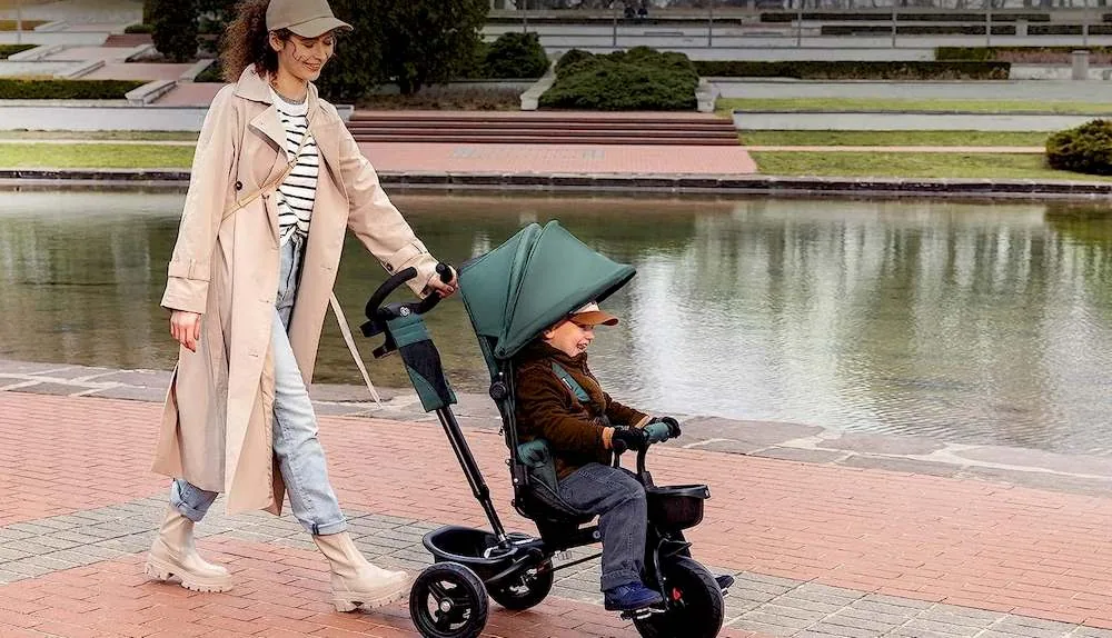 Une mère poussant son enfant sur le tricycle Kinderkraft